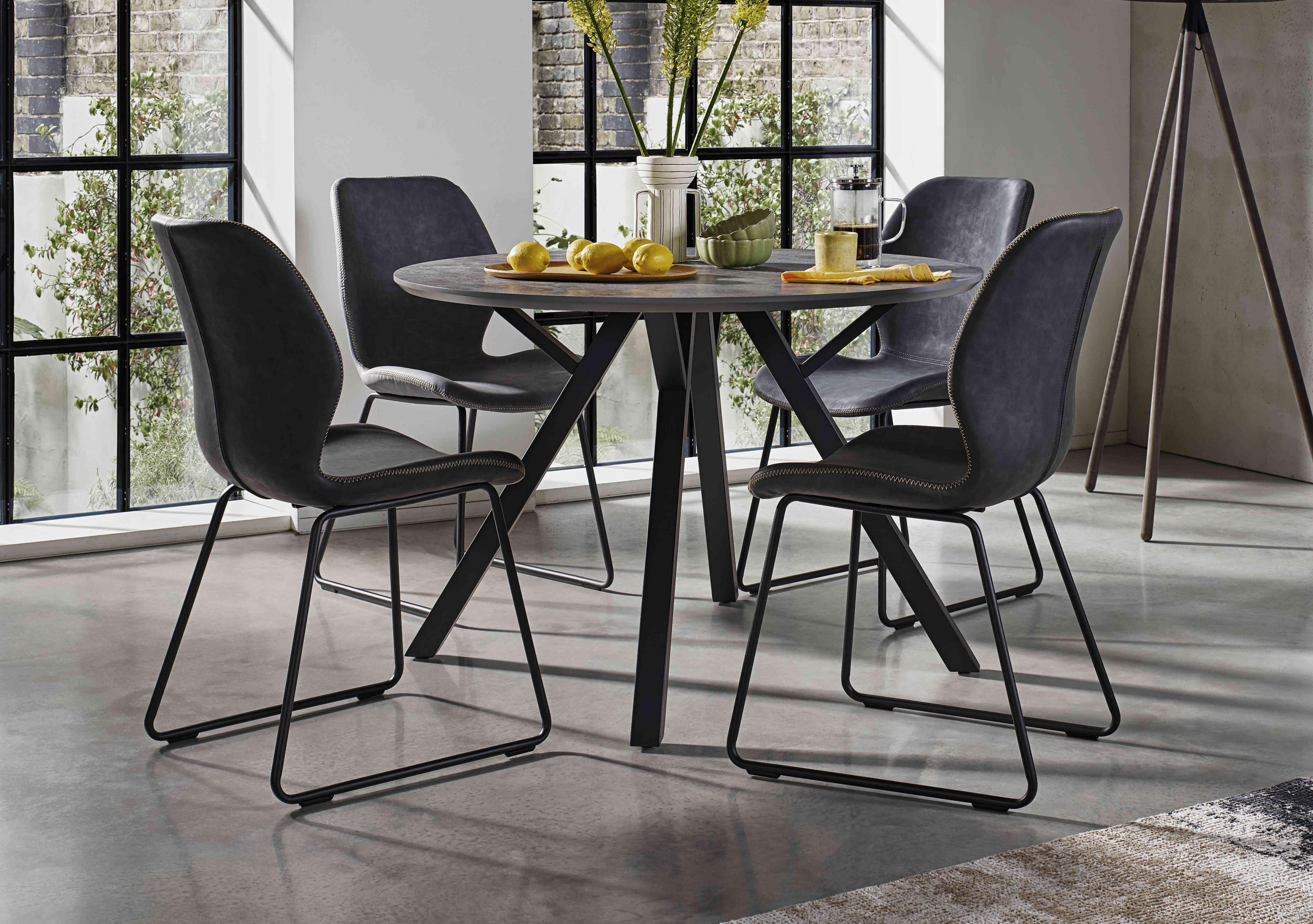 Matteo Round Dining Table with 4 Faux Leather Ski Leg Chairs in  on Furniture Village