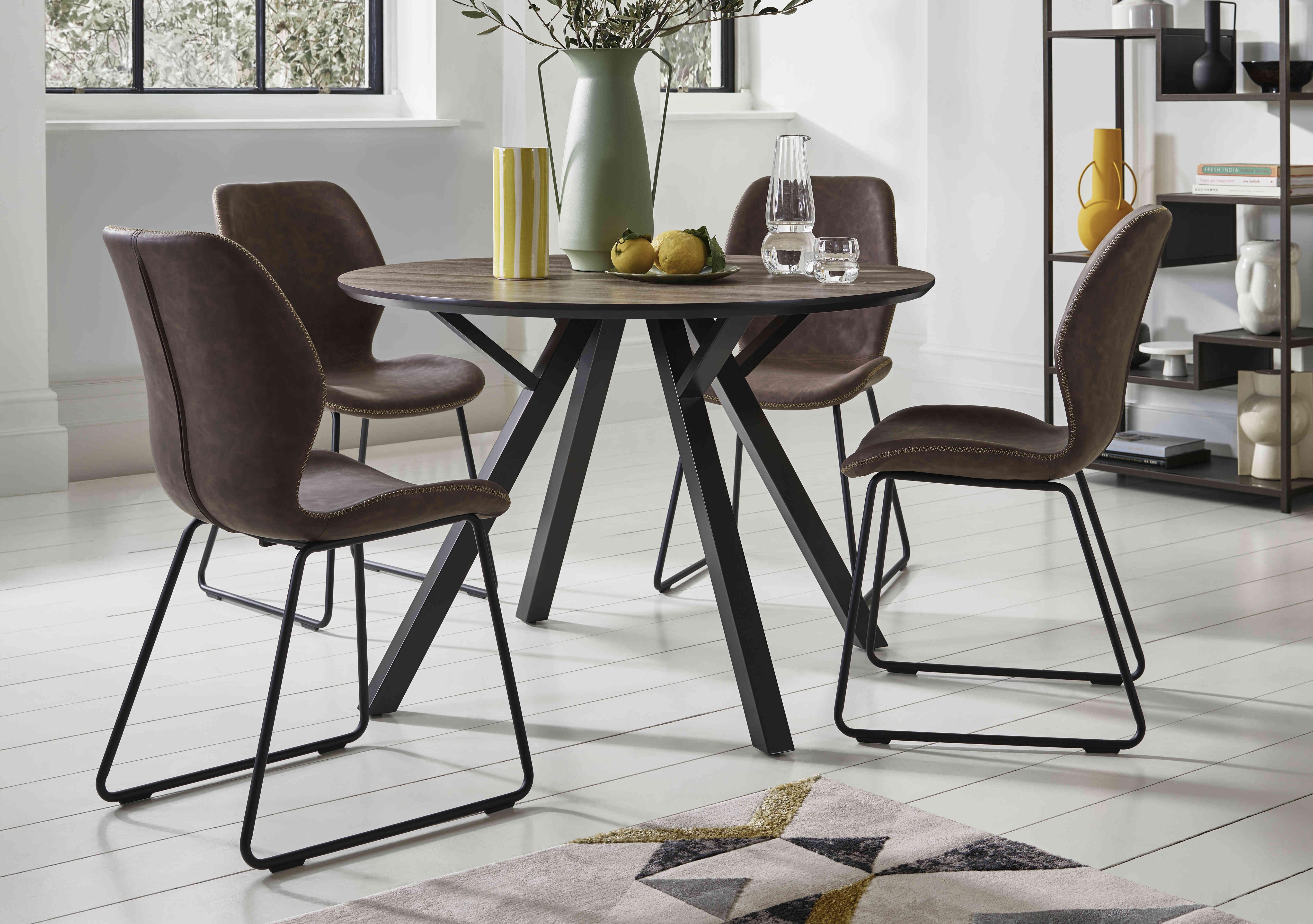Pedro Round Dining Table with 4 Faux Leather Ski Leg Dining Chairs in  on Furniture Village