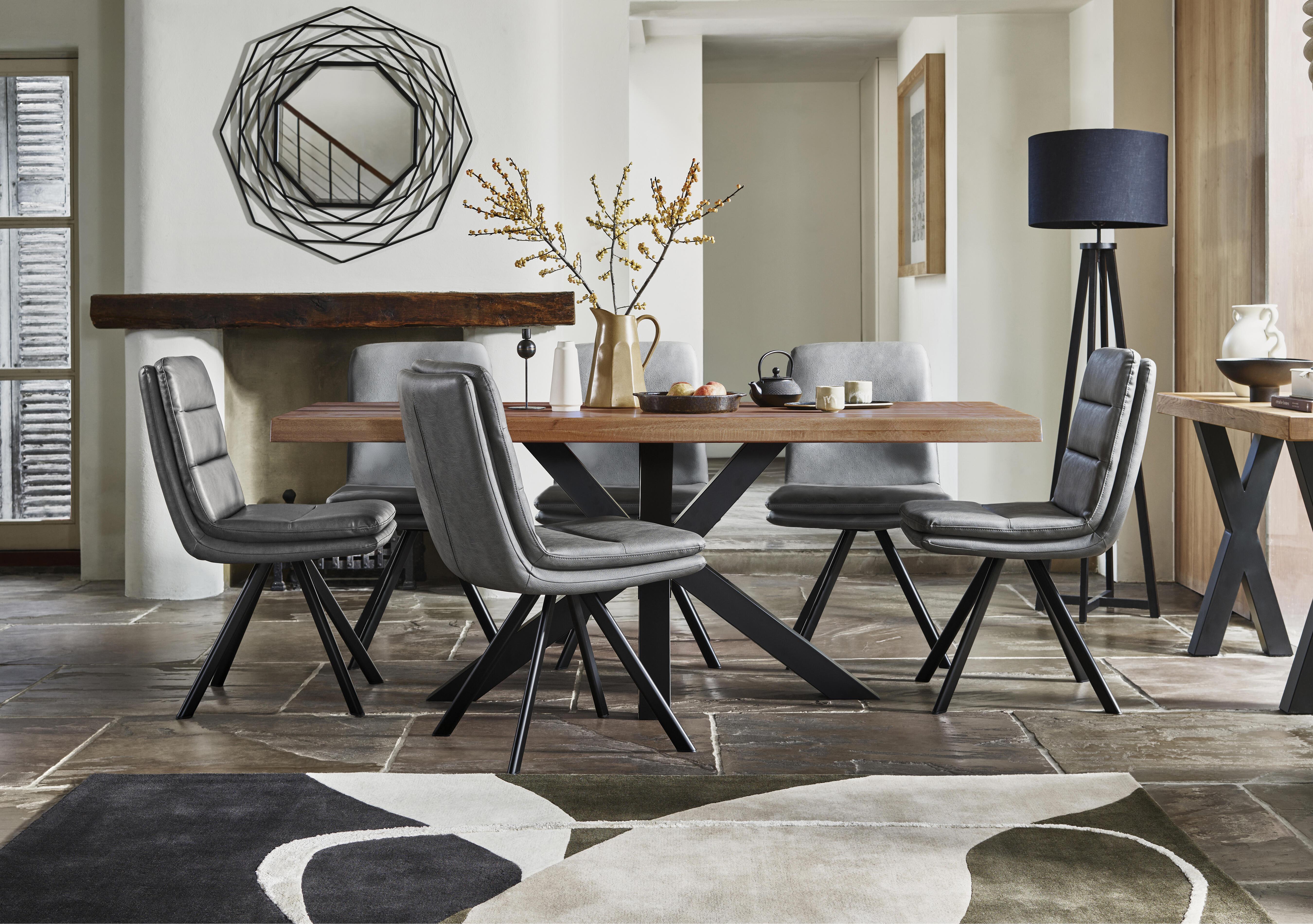 Njord Raw Edge Dining Table with Metal Star Base and 6 Grey Faux Leather Swivel Dining Chairs in  on Furniture Village